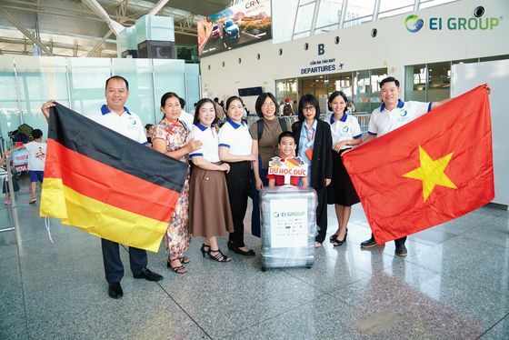 Học viên và gia đình cầm quốc kỳ Đức và Việt Nam